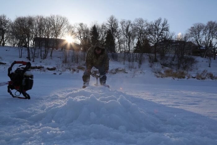 Pat Kehoe drills holes into the ice for a morning of fishing. Despite minus 34 C temperatures, Kehoe completes the task without gloves or a hat. 