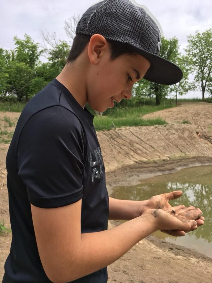 A tiny frog meets a young friend beside the new wetland area. 