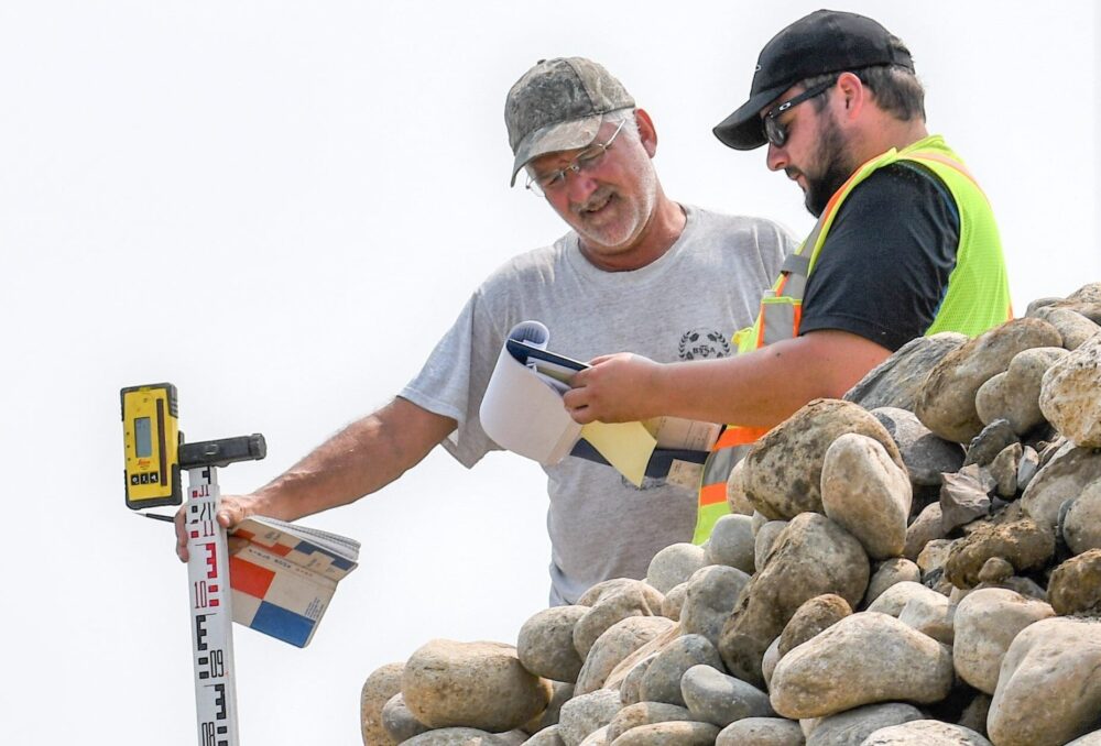 DUC engineer Dave Dobson (left) consults with fellow engineer, Patrick Lederman, as they work to replace an aging water control structure near Lenore.