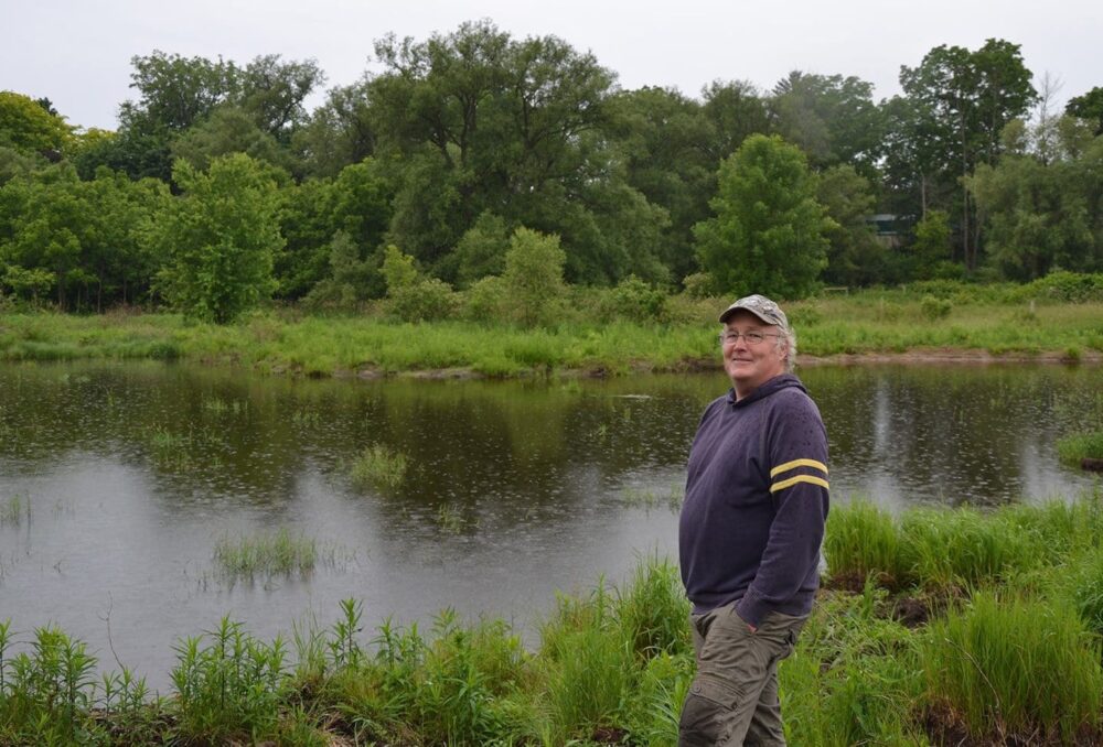 Newly minted conservationist Jeff Tribe poses proudly by the restored wetland. Tribe started the restoration process with a phone call to DUC