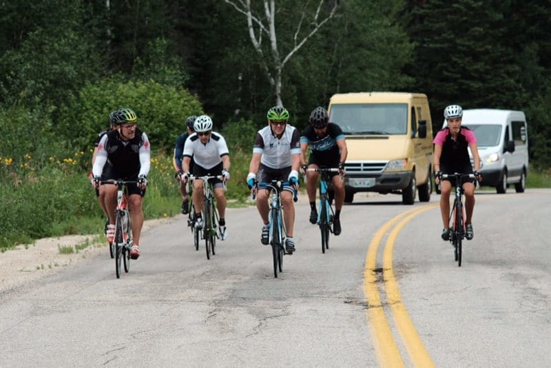 On the road: Cyclists hit the highway with one of two support vans during the 2018 Ride to the Lake.