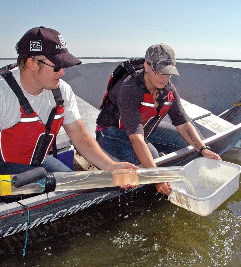 Two people taking water samples