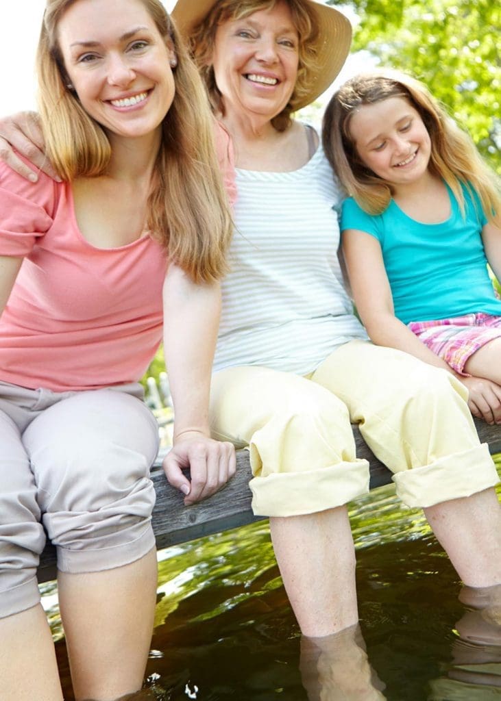 Photo of 3 generations of women sitting on a dock