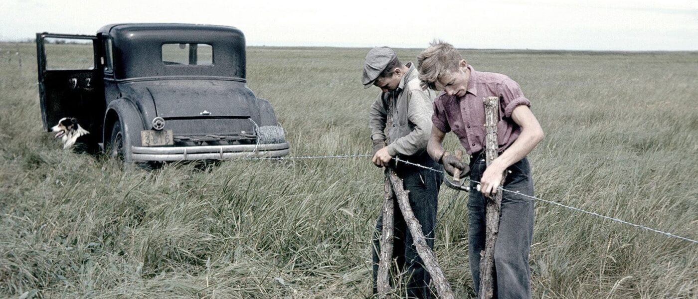 Two workers string a barbed wire fence at Big Grass Marsh.