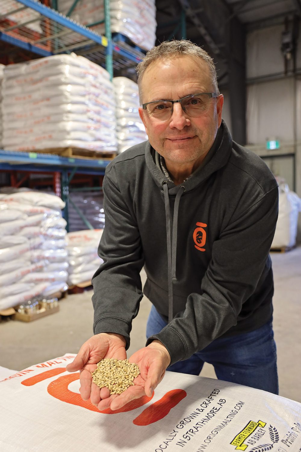 Spencer Hilton with a handful of barley to be used in his family's beer products. The Hiltons employ soil and wetland conservation systems on their farm to enhance the local environment.