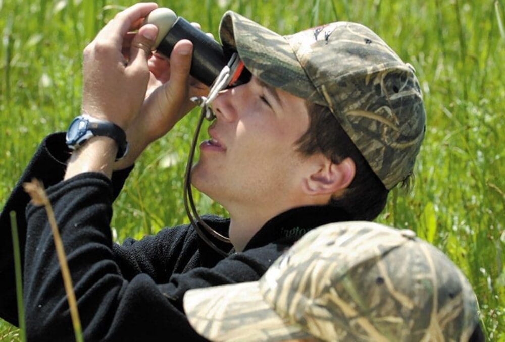 A young Mitch Weegman candles a scaup egg, alongside his twin brother, Matt. The two nurtured an early interest in ducks and an enthusiastic curiosity about the natural world.