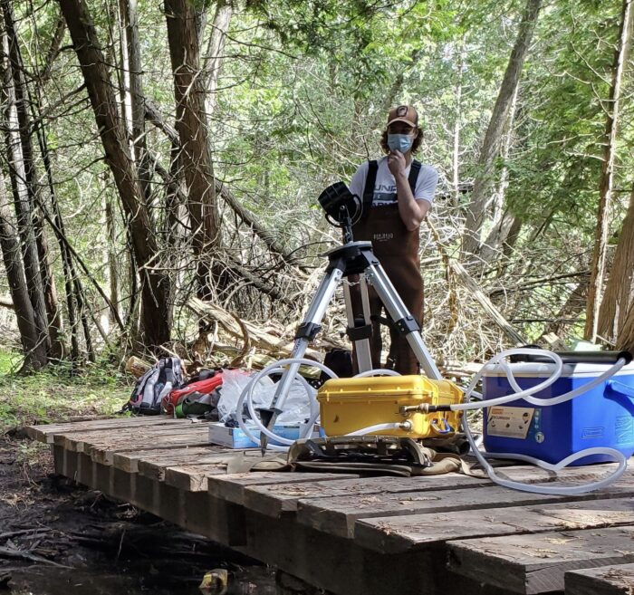 Nathan Zeinstra taking an environmental DNA sample for a Brook trout project at the University of Guelph