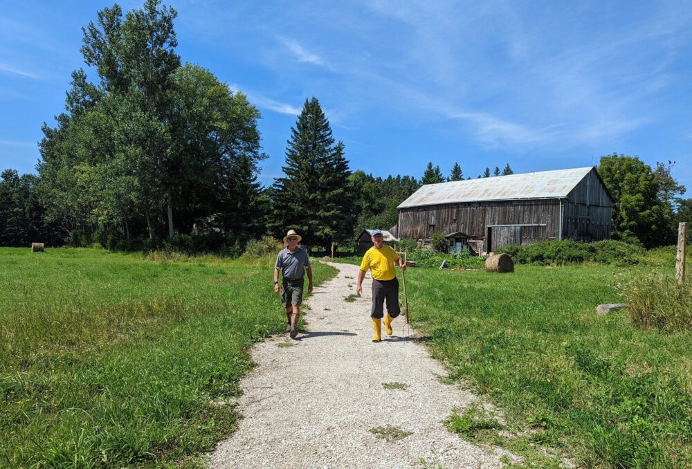 Landowner William Shotyk (right) and David McLachlin, DUC biologist, walking the property together to assess the health of the habitat.