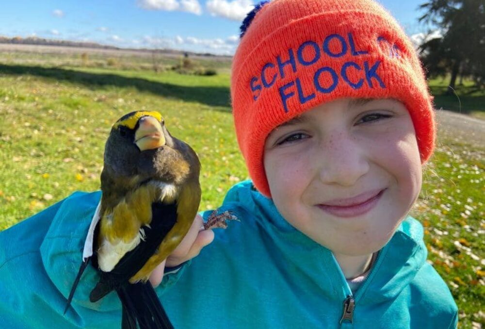 DUC Wetland Hero Lucy Harrison poses with a songbird she banded at Hilliardton Marsh, Ontario. Harrison learned her bird-handling skills as a volunteer and demonstrates the techniques to younger children. 
