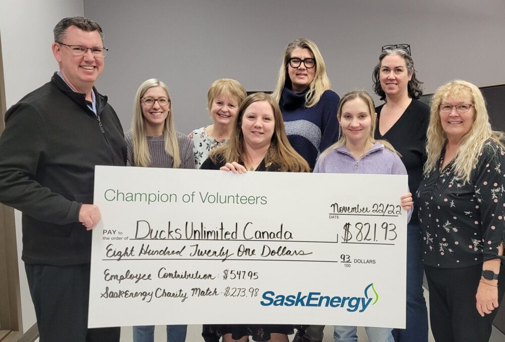 Weyburn SaskEnergy staff present DUC's Michael Champion with funds raised during their 2022 Spirit Week