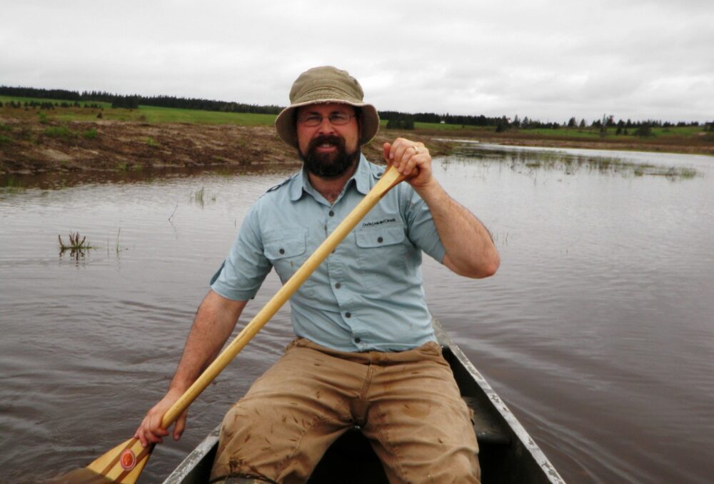 Adam Campbell explores a wetland by canoe.