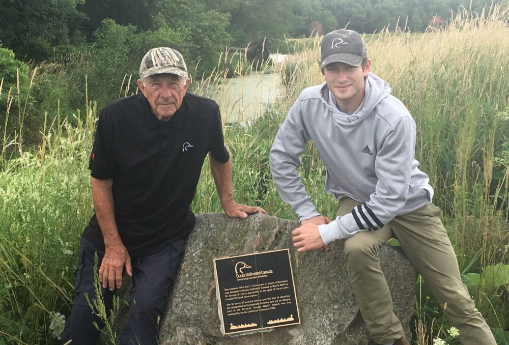 George Merry at LaSalle Marsh with his grandson, Angus, in 2018 flanking the plaque honouring his family’s gift of land