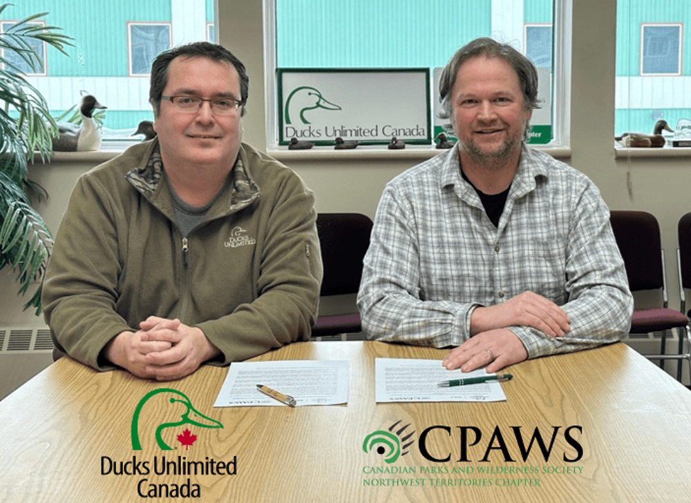 Barrett Lenoir, Conservation Programs Specialist of NWT and Kris Brekke, Executive Director of CPAWS-NWT sign Collaboration Agreement