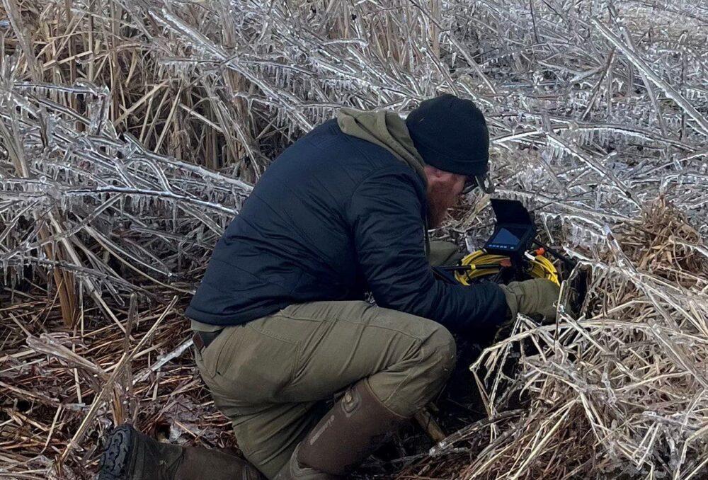 DUC conservation specialist Nick Krete investigates holes at Big Creek NWA looking for snakes.