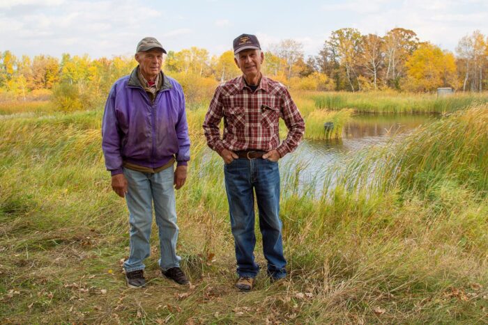 Brothers Ken and Don Crawford in front of the wetland they maintain 