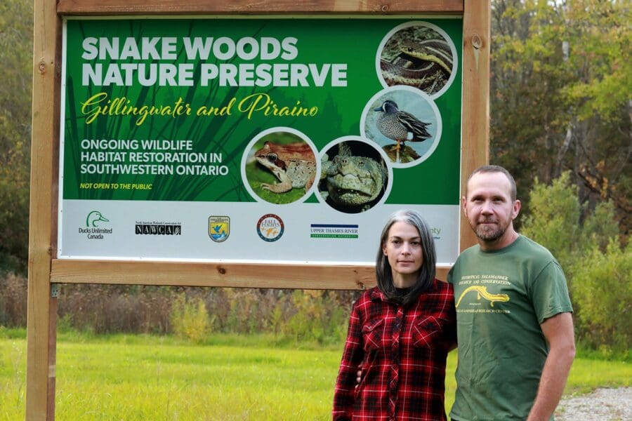 The gift of conservation: Teresa Piraino and Scott Gillingwater in front of Snake Woods Nature Preserve sign