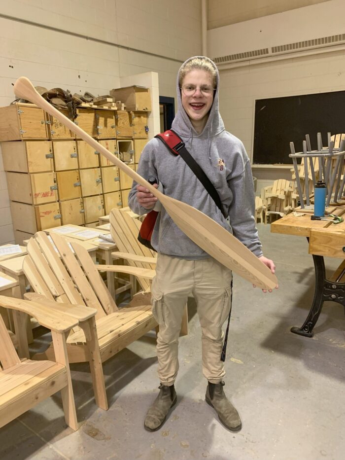 Geurts with a handmade canoe paddle at Charlottetown Rural High School 