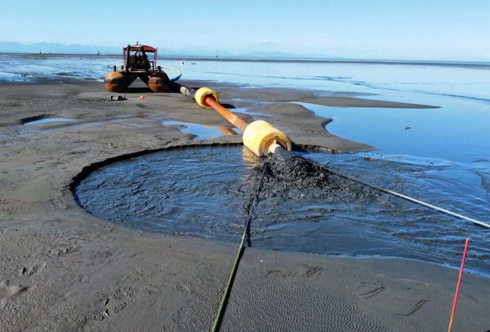 Sediment mixed with water flows from the barge to the pilot project site during low tide. Photo taken Sept 27, 2024.
