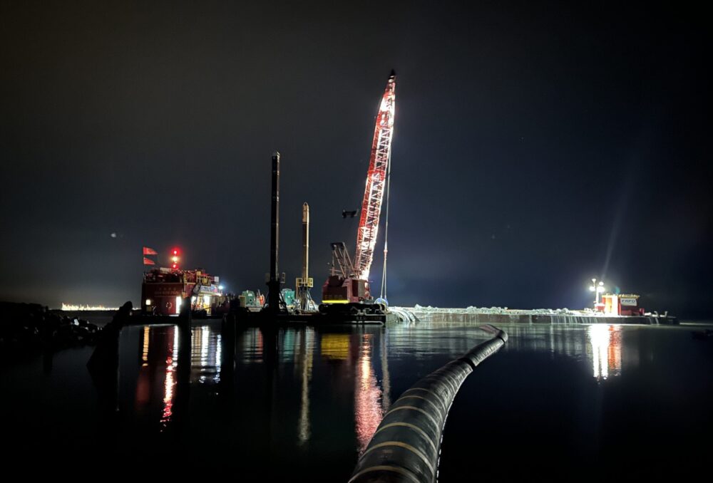 The final night of sediment addition. Sediment was transferred from the barge through the pipeline (both pictured) during the low and rising tide to support sediment retention. This timing often extended into the night, with staff monitoring works into the early morning.