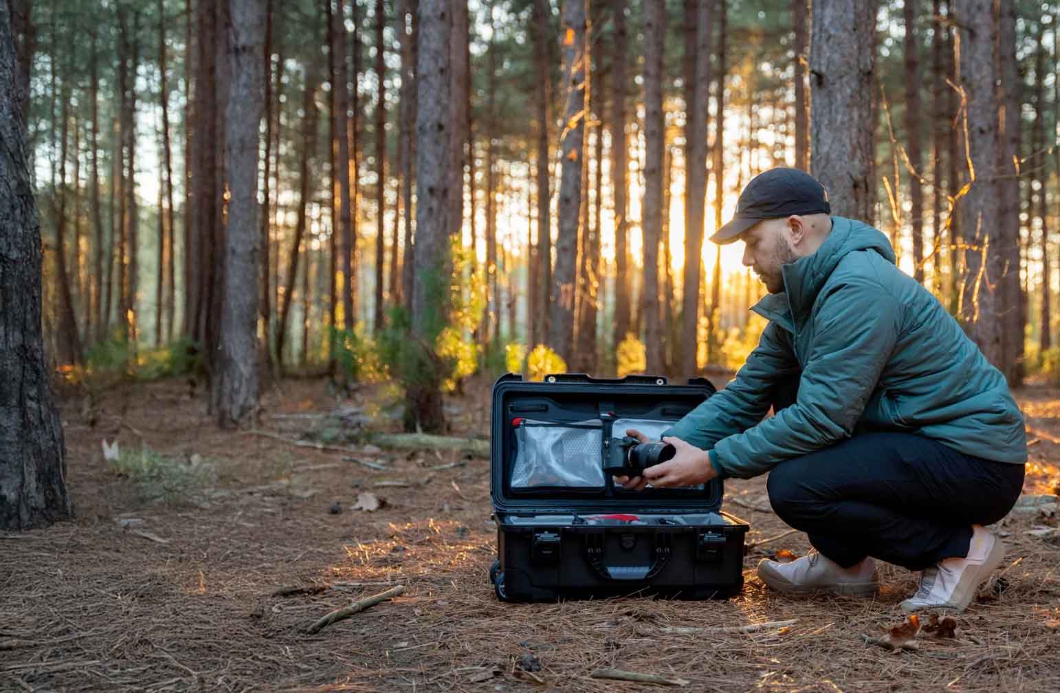 Man in the forest opening a Nanuk Black 935b
