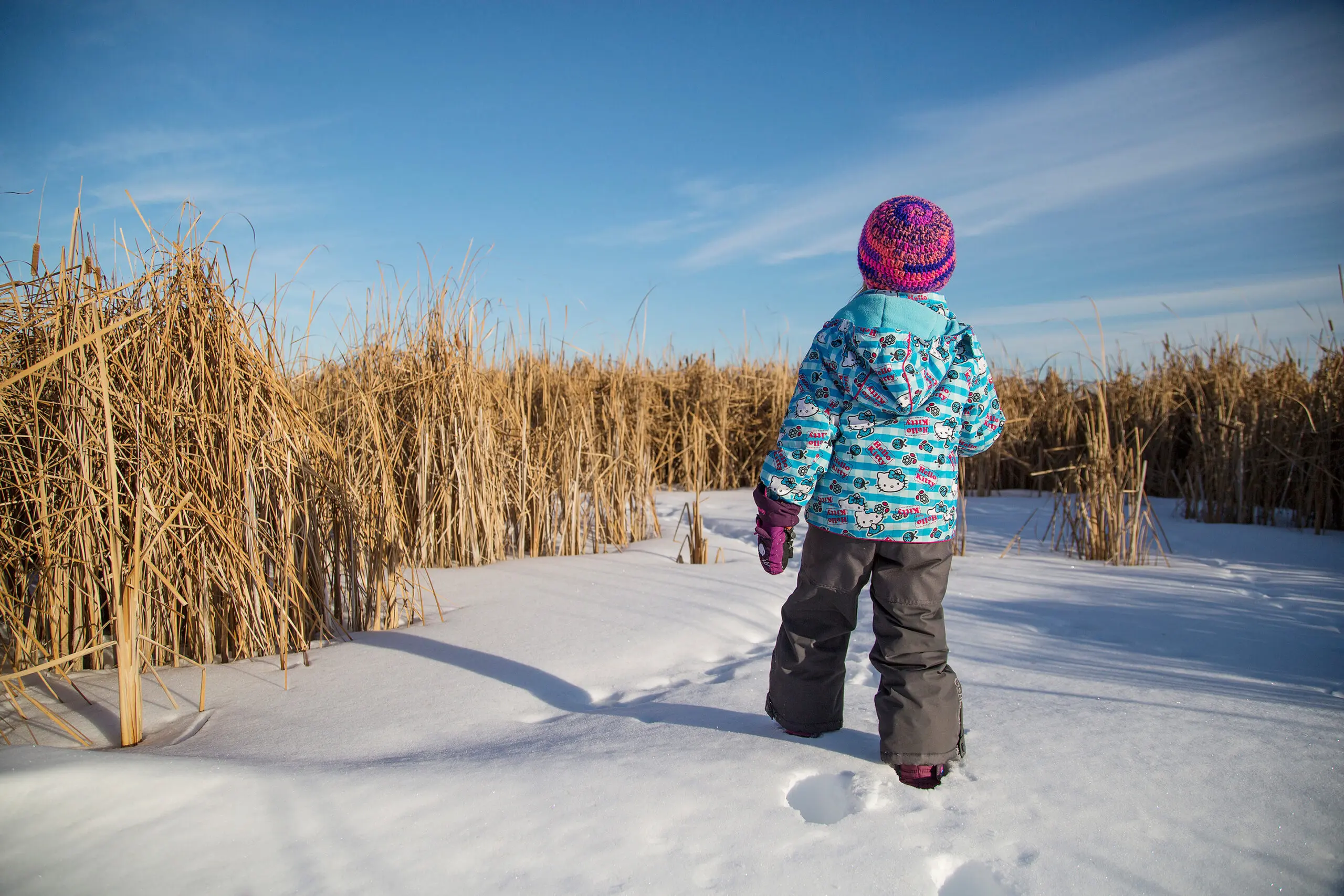Young child walking outside in the winter.
